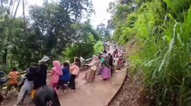 Residents of a village of mothers and children in indonesia are busy helping a car that has fallen into a ravine by pulling it with a rope