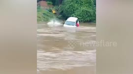 Youngsters jump from sinking car being washed away in flooded river
