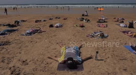 UK Weather leading up to Boardmasters Festival, Yoga participants lie dormant after exertions. Fistral Beach Cornwall UK