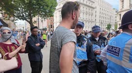 At the Free Palestine protest a man lashes out at a member of the press trying to grab their phone but police immediately break the conflict up.