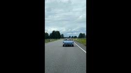 Two women driving a retro car on the motorway in Estonia