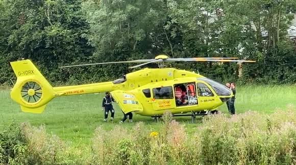 Ambulance crews complete the loading of the injured driver into the Yorkshire Air Ambulance after the van transporter accident near Little Hopgrove roundabout in York