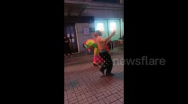 China: A man is wearing only a bellyband on the upper body, dancing with a lady