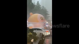 China: A huge inflatable doll is blown by the wind during rainstorm in Jieyang