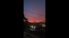 Flames from the forest fire illuminates night sky in Athens suburbs