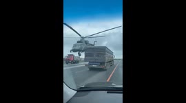 Military helicopter flies extremely low over traffic on highway in western Russia