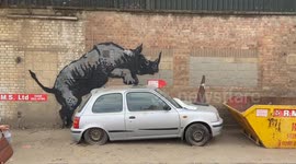 A rhino gets intimate with a car as Banksy unveils another new artwork