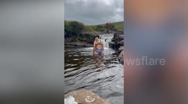 Woman enjoying quiet dip in the middle of nowhere interrupted by army exercise