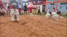 The excitement of the sack racing game using helmets which is very funny in Indonesia
