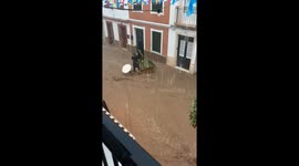 Two people rescue table and plant from flood waters in Es Mercadal, Menorca