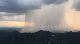 Stunning video captures rainstorm cascading like a waterfall over Chinese city