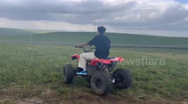 China: A young man was riding an ATV back and forth on the grass