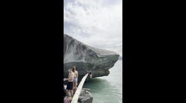 Climber's impressive show of strength as he scales steep rock overhanging ocean in Canada
