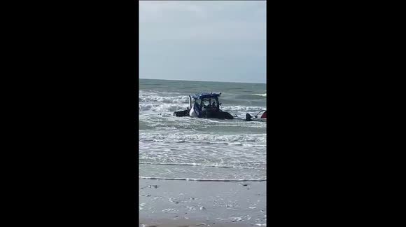 Tractor gets stuck in the sand. the rising water means the end of this tractor