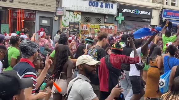 Notting Hill Carnival Revellers spray the crowds with colourful paint and powder
