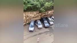 Driver escapes with SUV seconds before retaining wall crushes seven nearby vehicles