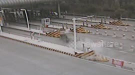 Out-of-control car speeds into motorway toll booth and flips over