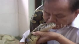 68-year-old man sleeps and eats with boa