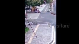 Cyclist taken out by falling lamp post