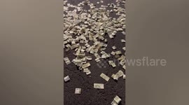 Thousands of bank notes scattered across busy road after car boot suddenly opens