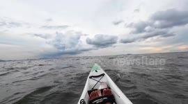 Kayaker encounters huge whale splashing in the sea