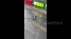 Passersby come to aid of woman and children knocked down by typhoon winds in southern China