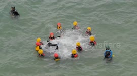 Coasteering group enjoy the elements of wild waves and rugged rocks, All year sport. Cornwall UK