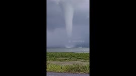 The natural phenomenon of a waterspout, a strong tornado over the water of Lake Tondano, Indonesia.