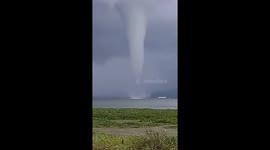 The natural phenomenon of a waterspout, a strong tornado over the water of Lake Tondano, Indonesia.