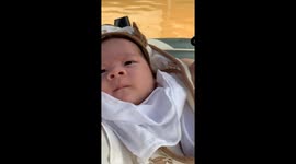 Family transport 2-month-old child on raft as floodwaters submerge neighbourhoods in Vietnam