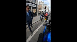 Curious pedestrian wanting to purchase a moped approaches friendly London biker