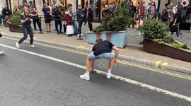 Man throws iPhone into the air and people queue outside the Apple store in London as iPhone 16 goes on sale