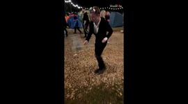 Festival humor: Drunk man in formal attire eats chips with enthusiasm