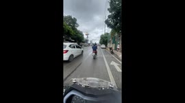 Motorcycle passenger sits on luggage in Manila, Philippines