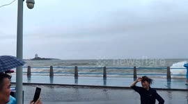Powerful waves crash over seawall, dragging locals to ground in eastern China