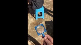 Prankster burns his friend's bald head with a magnifying glass