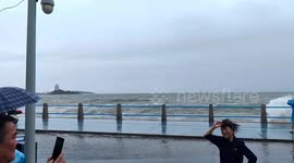 Waves crash into tourists in Qingdao, China