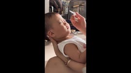 Aunt playfully applies fake eyelashes on child at home in China