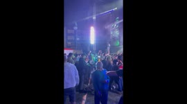 Man Balances Drink on His Forehead During Concert