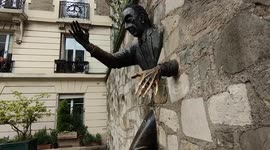 The Passe-Muraille (~Wall Passer) is one of the most surprising statues in Paris. Installed on Place Marcel Aymé in the heart of the 18th arrondissement, it sits here and has amazed passers-by since 1989. And it is no coincidence: this statue is in fact a