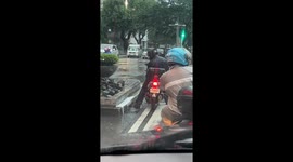 Motorcyclist attempts drainage clearance during stoplight in Makati