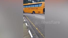 School bus gets stuck in hole on road