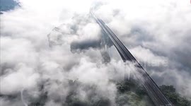 Train pierces through fog as it passes over shrouded bridge in China