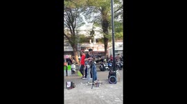 Musician and costumed cat busk on streets of Jakarta