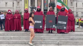 A silent protest with a partly dressed woman amongst handsmaids was held in central London to highlight the in justice to Ahoo Daryaei and women in Iran.  London /UK