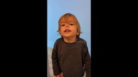 Cute little boy makes silly pinched nose face at camera