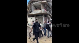 A man appears with leg of a “child who was torn from her innocent body in the attack on the Abu Riyal family home”