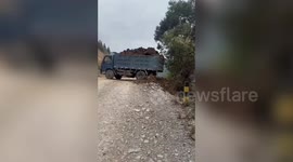 Terrifying moment overloaded lorry flips and plunges into ravine while dumping soil