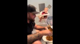 Baby mimics eating gesture while observing others in Florida