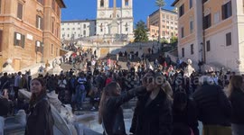 Tourists take selfies at Piazza di Spagna on a beautiful November day with the Spanish Steps in the background.